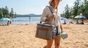 Portable soft-sided top rated beach cooler being carried to a sandy Canadian beach, ideal for easy transport.