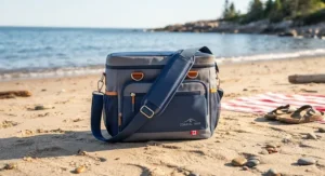 A portable soft-sided beach cooler with a comfortable shoulder strap, ideal for carrying gear to a Canadian ocean beach.