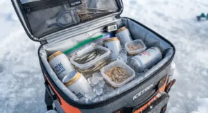 Open interior of an insulated backpack cooler for ice fishing loaded with cold beverages and bait.